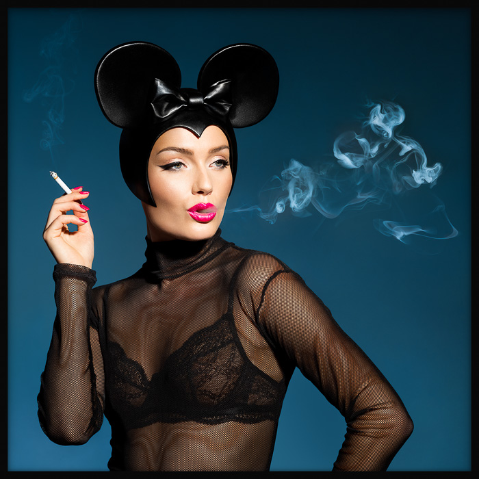 High fashion Minnie Mouse smoke art: stylish woman in Minnie Mouse headgear exhales Mickey-shaped smoke, in a whimsical and chic twist.