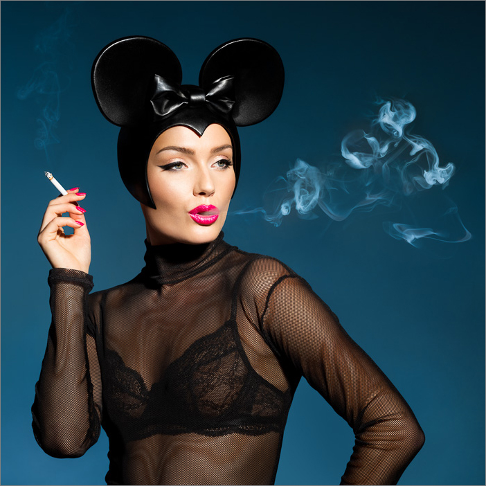 High fashion Minnie Mouse smoke art: stylish woman in Minnie Mouse headgear exhales Mickey-shaped smoke, in a whimsical and chic twist.