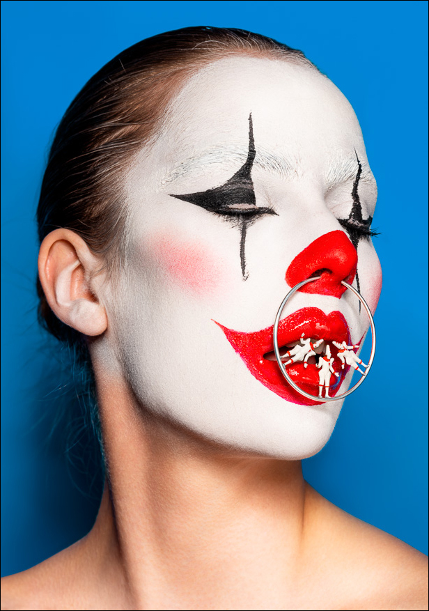 Surreal clown portrait of a female clown, eyes closed, with Pierrots balancing on a silver nose ring—mysterious, dreamlike, theatrical.