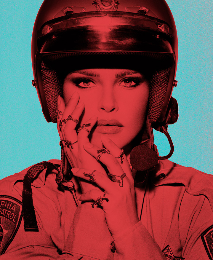 Bold colored B/W artwork of a young female police officer with gun rings, exploring strength, gender, and authority in modern society.