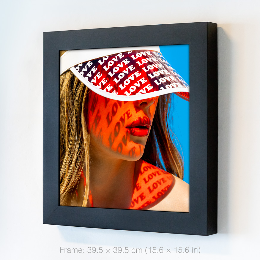 Red love projection on skin, radiant sunlight casting patterns of the word love on a woman's face and shoulder, creating summer vibes.