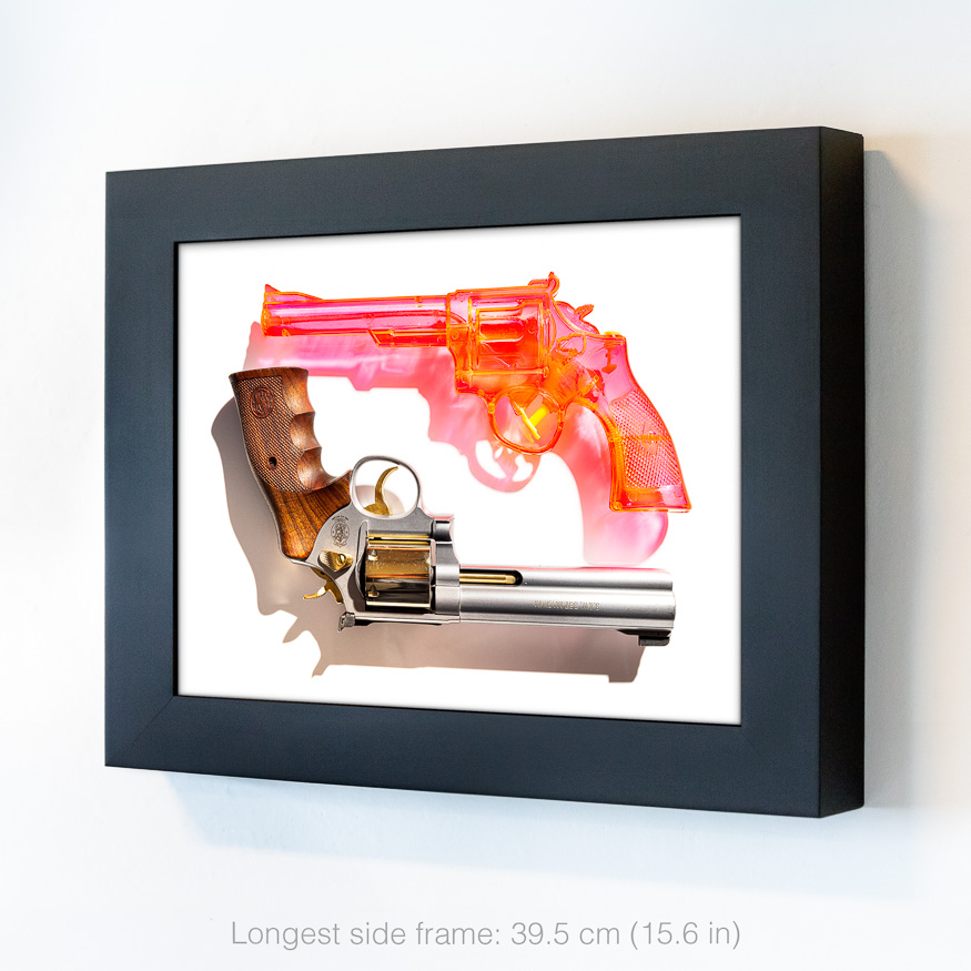 TOY AND TRIGGER: A pink translucent toy-like gun hovers above an upside-down Smith & Wesson Magnum revolver on a plain background.